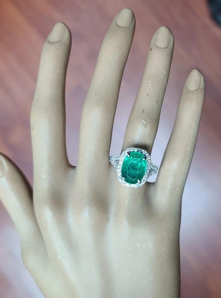 14K WHITE GOLD ENGAGEMENT RING 5.03CT NATURAL GREEN EMERALD OVAL SHAPE: This beautiful 14k white gold ring features a stunning 5.03ct natural green emerald in an oval shape. The gemstone is treated with oil and has a clarity grade eye clean, making it a high-quality piece