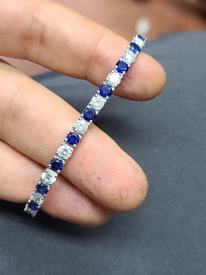14K WHITE GOLD TENNIS BRACELET 12.52CT. ROUND BLUE SAPPHIRE NATURAL DIAMONDS: 14K WHITE GOLD TENNIS BRACELET 12.52CT. ROUND BLUE SAPPHIRE NATURAL DIAMONDS This 14k White Gold Tennis Bracelet features 12.52ct. Of round blue diffused treated sapphire and natural diamond accents. 