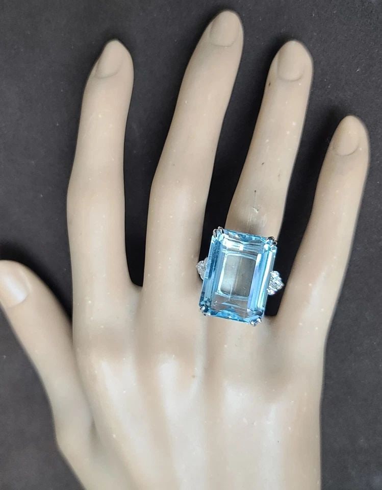 VINTAGE 14K WHITE GOLD ENGAGEMENT RING 25.29CT.NATURAL AQUAMARINE EMERALD SHAPE: VINTAGE 14K WHITE GOLD ENGAGEMENT RING 25.29CT.NATURAL AQUAMARINE EMERALD SHAPE This vintage 14k white gold engagement ring is a stunning piece with a beautiful natural aquamarine gemstone. The rectan