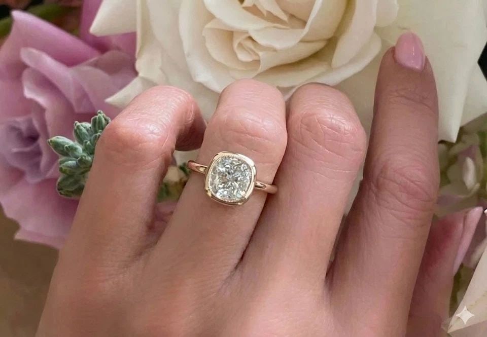 VINTAGE 14K ROSE GOLD ENGAGEMENT BEZEL RING 2.39CT. CUSHION SHAPE DIAMOND: VINTAGE 14K ROSE GOLD ENGAGEMENT BEZEL RING 2.39CT. CUSHION SHAPE DIAMOND Make an unforgettable statement with this breathtaking vintage engagement ring, masterfully crafted in 14K rose gold. At its c