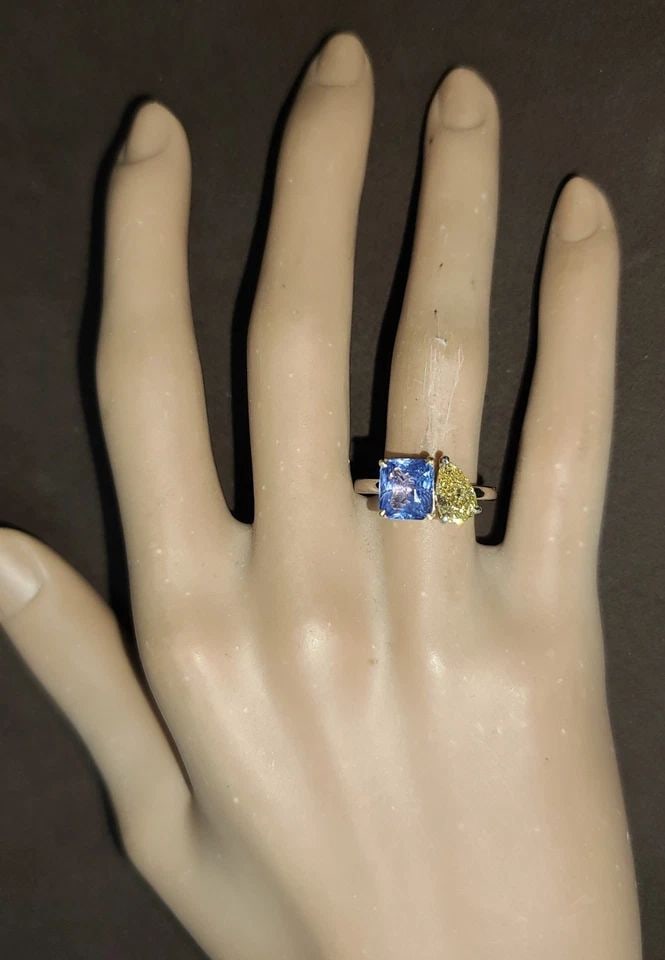 14K WHITE GOLD 3.43CT. NATURAL BLUE SAPPHIRE DIAMOND PEAR TOI ET MOI RING: This is a 14k white gold ring with a 2.53ct natural blue sapphire as the main stone. The sapphire is emerald shaped and has a prong setting. The ring also has one lab-grown yellow diamond as a seconda