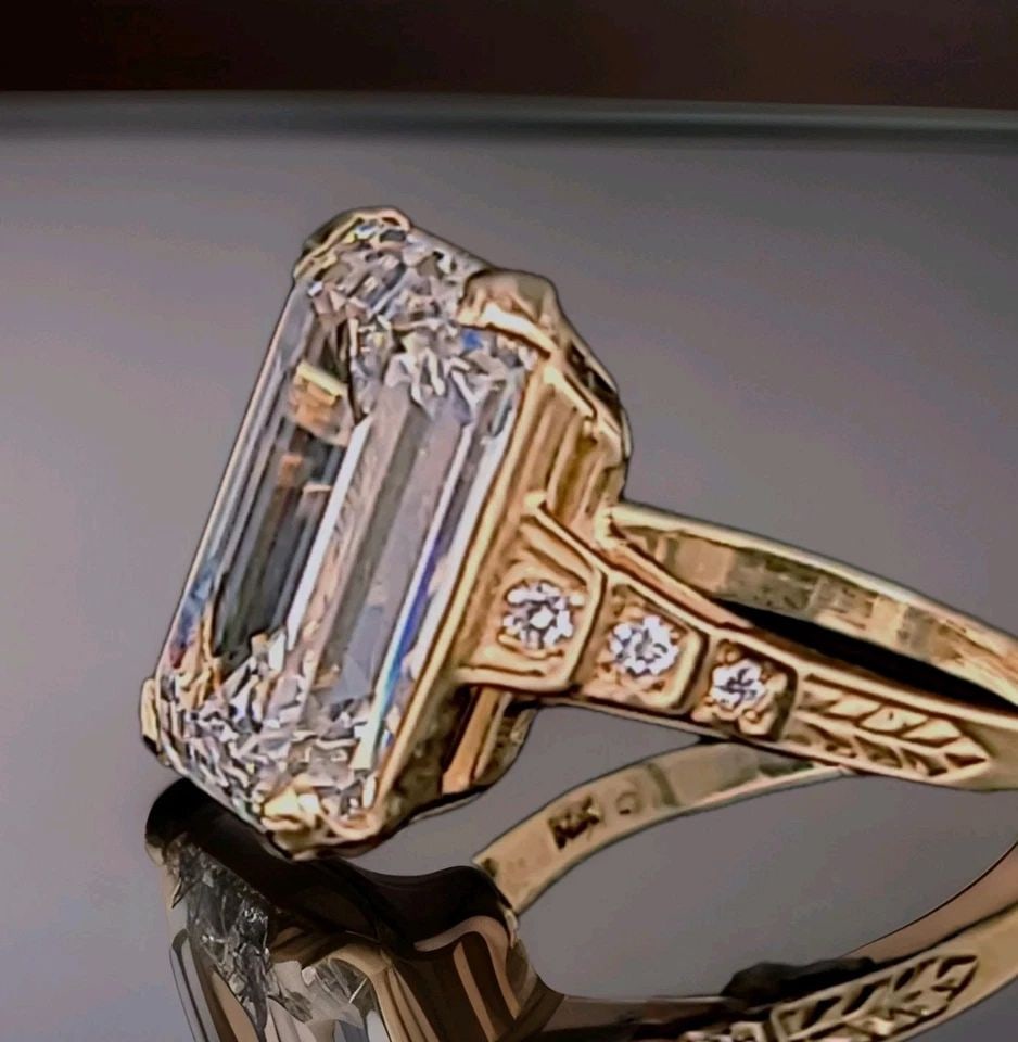 VINTAGE 14K YELLOW GOLD ENGAGEMENT RING 7.73CT. LAB-GROWN DIAMOND EMERALD CUT: VINTAGE 14K YELLOW GOLD ENGAGEMENT RING 7.73CT. LAB-GROWN DIAMOND EMERALD CUT Vintage filigree 14K yellow gold ring featuring an elegant openwork design. The center is set with a stunning lab-grown re