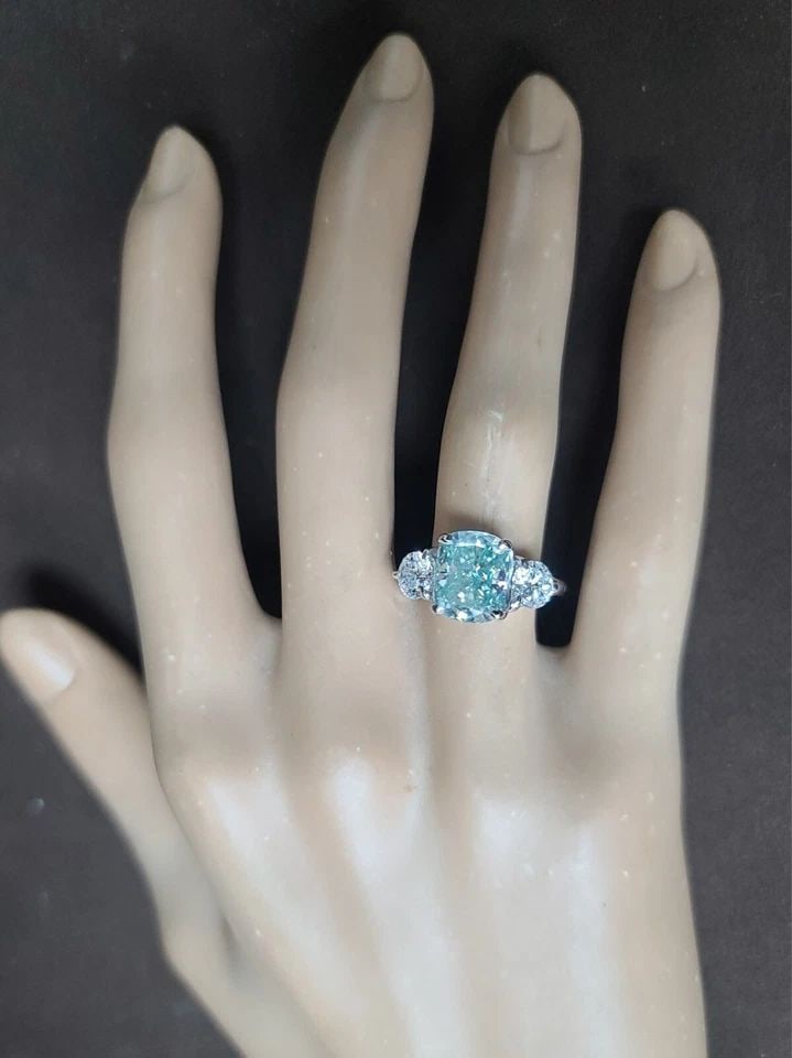 VINTAGE PLATINUM 3.49CT. BLUE MOISSANITE DIAMOND ENGAGEMENT RING CUSHION CUT: VINTAGE PLATINUM 3.49CT. BLUE MOISSANITE DIAMOND ENGAGEMENT RING CUSHION CUT Vintage platinum engagement three-stone ring. Center set gorgeous blue moissanite diamond weight 3.49CT. In cushion cut siz