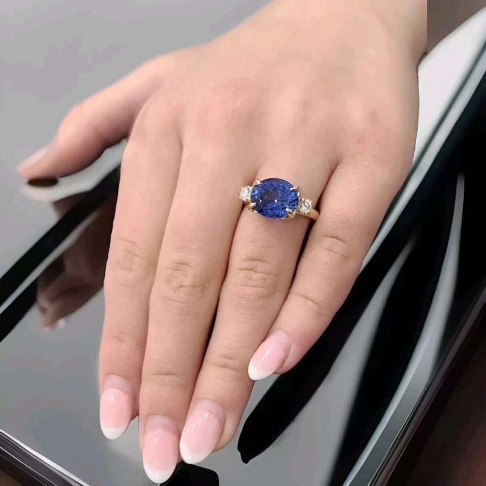 14K YELLOW GOLD ENGAGEMENT RING 6.18CT. LAB GROWN BLUE SAPPHIRE OVAL SHAPE: 14K YELLOW GOLD ENGAGEMENT RING 6.18CT. BLUE SAPPHIRE OVAL SHAPE This 14k yellow gold engagement ring is a beautiful and timeless piece of jewelry. The oval shape and blue sapphire lab-grown stone mak