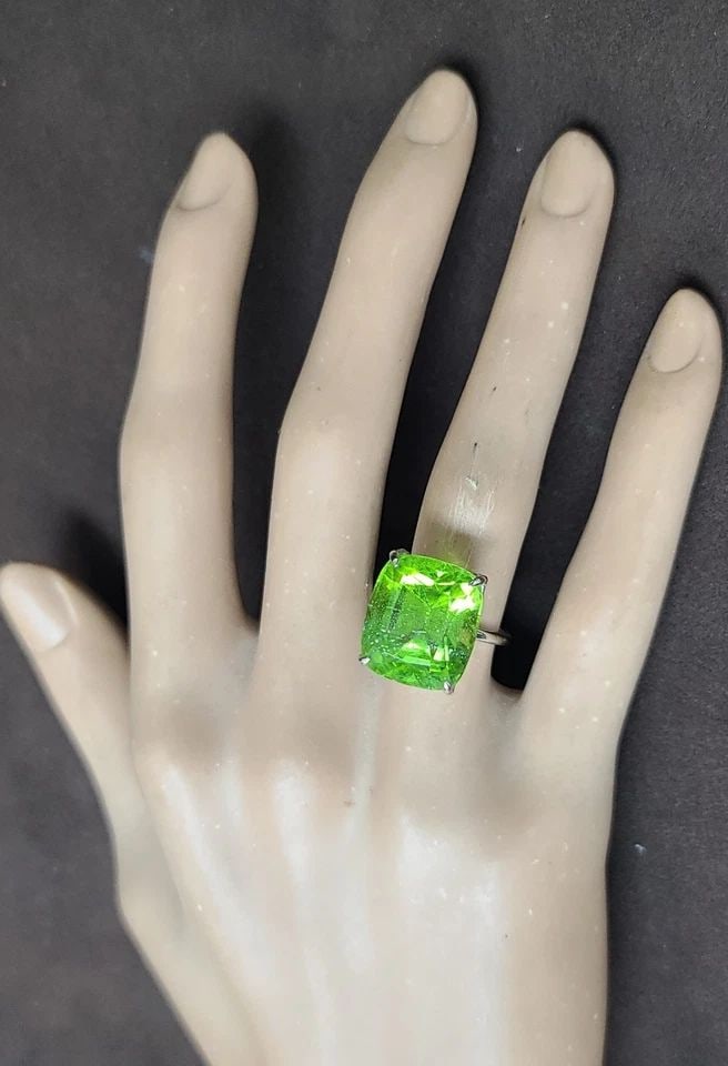 VINTAGE 14K WHITE GOLD ENGAGEMENT RING 21.01CT. NATURAL GREEN PERIDOT CUSHION: VINTAGE 14K WHITE GOLD ENGAGEMENT RING 21.01CT. NATURAL GREEN PERIDOT CUSHION This vintage 14k white gold engagement ring features a stunning 21.01CT natural green peridot cushion as the main stone. T