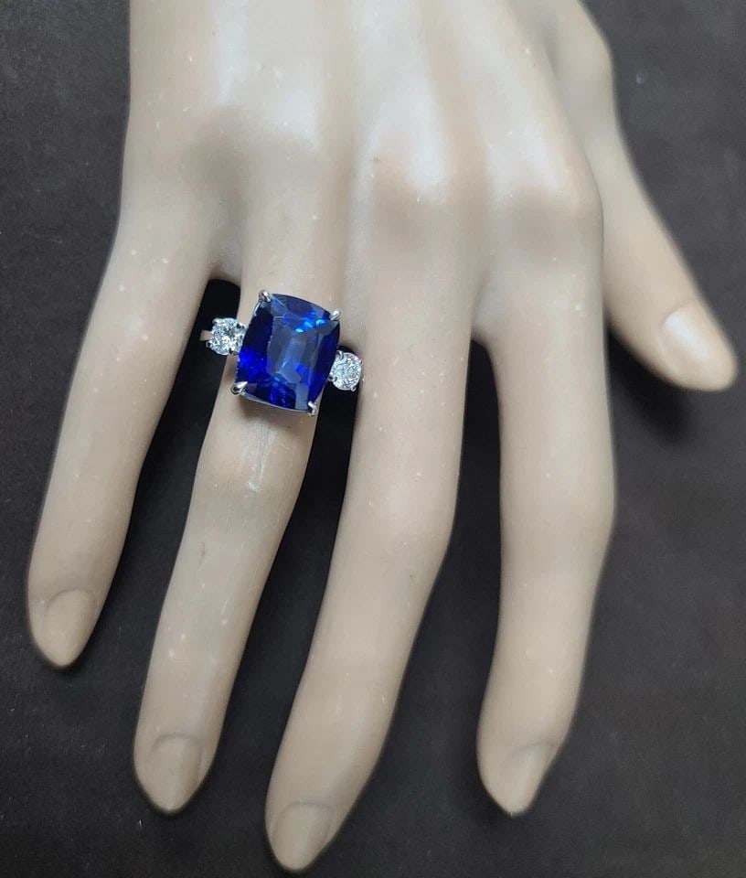 VINTAGE PLATINUM ENGAGEMENT THREE-STONE RING 9.63CT. BLUE SAPPHIRE CUSHION CUT: VINTAGE PLATINUM ENGAGEMENT THREE-STONE RING 9.63CT. BLUE SAPPHIRE CUSHION CUT This vintage platinum three-stone ring features a stunning cushion-shaped lab-grown blue sapphire as its center stone, wi