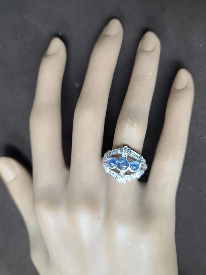 VINTAGE PLATINUM RING 1.35CT. NATURAL BLUE SAPPHIRE CABOCHON ROUND CIRC 1930'S: VINTAGE PLATINUM RING 1.35CT. NATURAL BLUE SAPPHIRE CABOCHON ROUND CIRC 1930'S This Vintage Platinum Ring from the 1930s features a stunning natural blue sapphire cabochon as the main stone, with a to