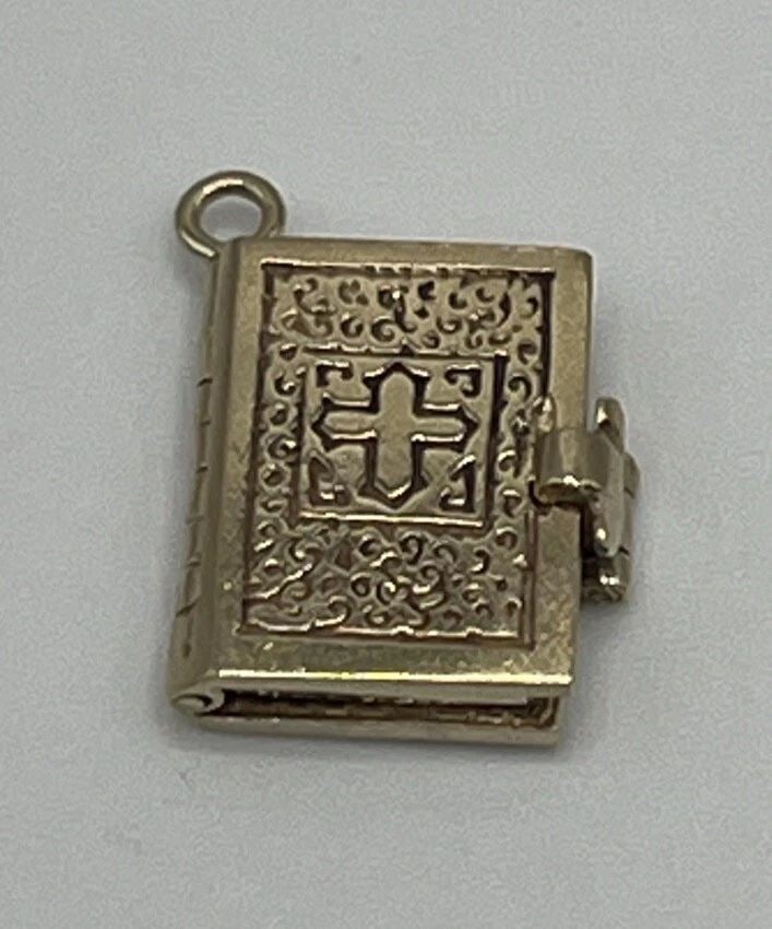 14K YELLOW GOLD BIBLE CHARM: 14K YELLOW GOLD BIBLE CHARM 14K YELLOW GOLD BIBLE CHARM This beautiful Bible charm is made of 14k yellow gold, adding a touch of elegance to any necklace or pendant. The intricate design showcases exq