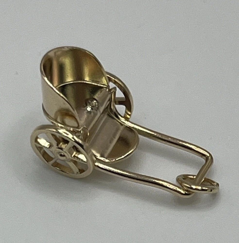 14K YELLOW GOLD CARRIAGE CHARM: 14K YELLOW GOLD CARRIAGE CHARM 14K YELLOW GOLD CARRIAGE CHARM This charming 14K yellow gold pendant is perfect for anyone looking to add a touch of whimsy to their jewelry collection. The pendant take