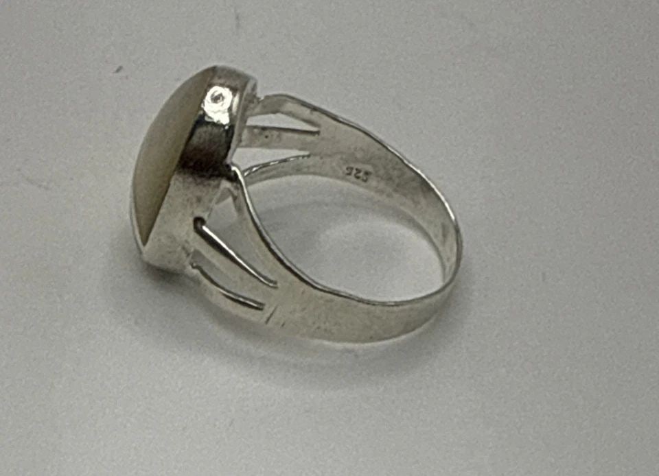 STERLING SILVER AND MOTHER OF PEARL RING SIZE 6.5: STERLING SILVER AND MOTHER OF PEARL RING SIZE 6.5 This sterling silver ring with a mother of pearl/abalone main stone is a beautiful piece of fine jewelry. The white mother of pearl adds a touch of el