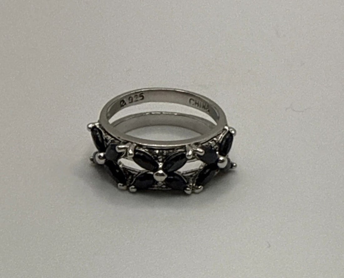 STERLING SILVER RING WITH BLACK STONES SIZE 5: STERLING SILVER RING WITH BLACK STONES SIZE 5 This sterling silver ring with black stones, size 5, is a stunning piece of fine jewelry. The black stones serve as the main focal point of the ring, addi