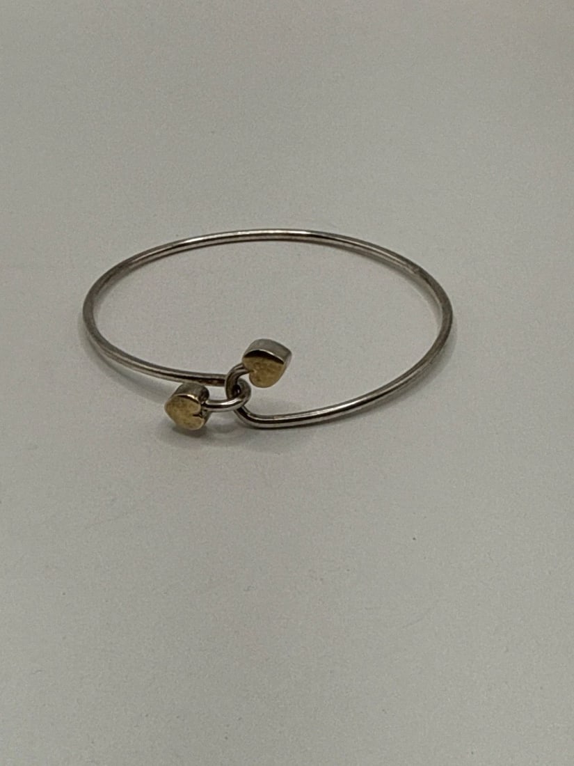 TIFFANY & CO 18K GOLD SILVER DOUBLE HEART HOOK BANGLE BRACELET 7" WRIST SIZE: TIFFANY & CO 18K GOLD SILVER DOUBLE HEART HOOK BANGLE BRACELET 7" WRIST SIZE The Tiffany & Co. 18K Gold Silver Double Heart Hook Bangle Bracelet is a luxurious piece of fine jewelry that exudes elegan