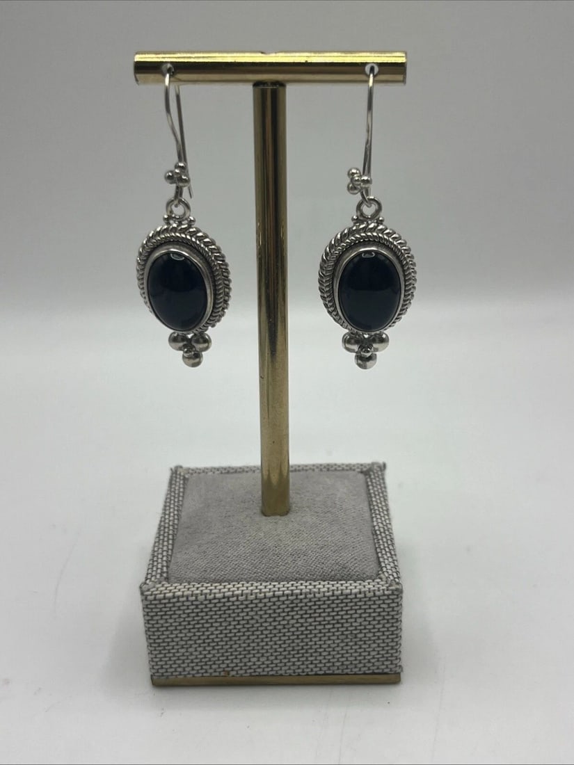 STERLING SILVER & BLACK ONYX BOHO EARRINGS: STERLING SILVER & BLACK ONYX BOHO EARRINGS STERLING SILVER & BLACK ONYX BOHO EARRINGS These sterling silver boho earrings feature black onyx stones in an oval shape, creating a stylish dangle/drop des