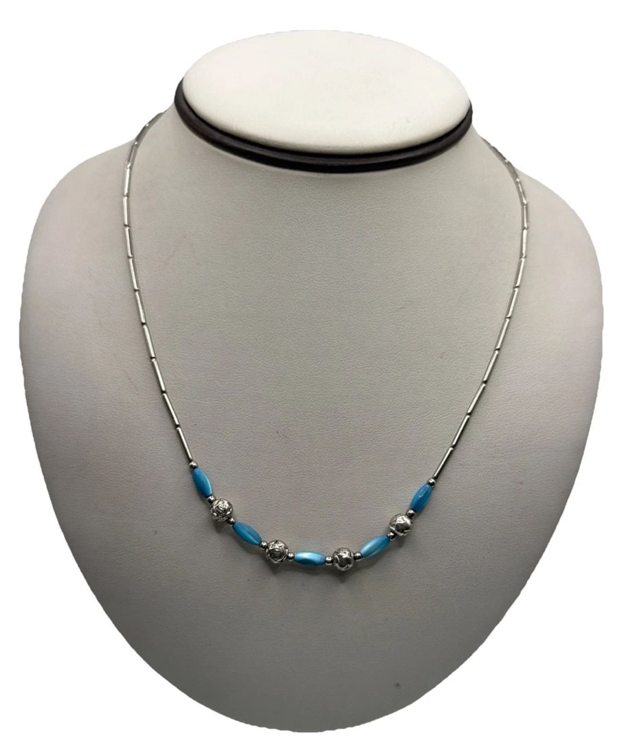 SILVER & TURQUOISE NECKLACE 17": SILVER & TURQUOISE NECKLACE 17" This Silver & Turquoise Necklace features a beautiful blue turquoise stone set in a silver beaded design. The necklace is 17 inches long and showcases the vibrant blue 