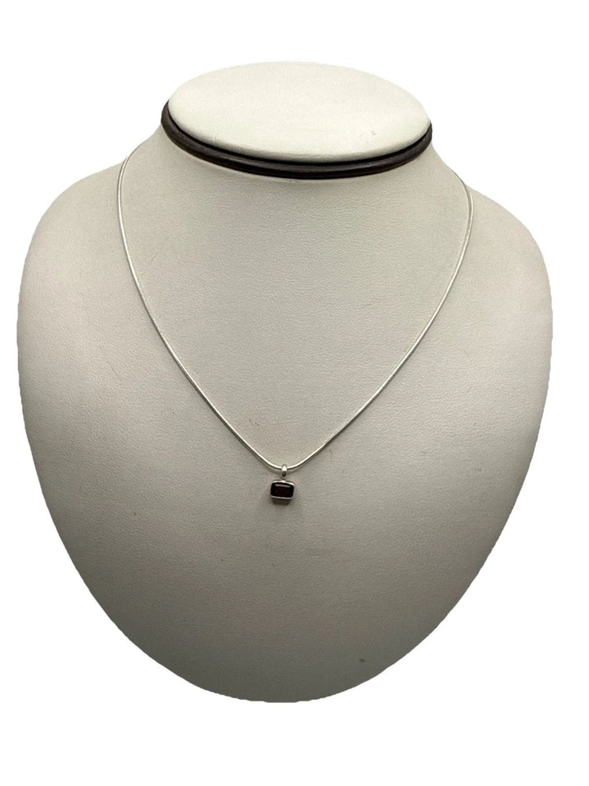 STERLING SILVER 16" SNAKE CHAIN WITH RED STONE CHARM: STERLING SILVER 16" SNAKE CHAIN WITH RED STONE CHARM The product is a 16" sterling silver snake chain necklace featuring a red stone charm. The necklace has a metal purity of 925 sterling silver and s