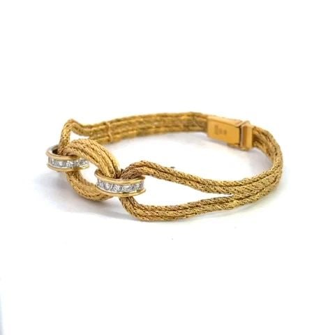 BUCHERER DIAMOND BRACELET 18K YELLOW GOLD LOOP STYLE SWISS: BUCHERER DIAMOND BRACELET 18K YELLOW GOLD LOOP STYLE SWISS This elegant bracelet is by designer Bucherer, it is crafted from 18k yellow gold featuring a multi-chain twisted rope like style. The center