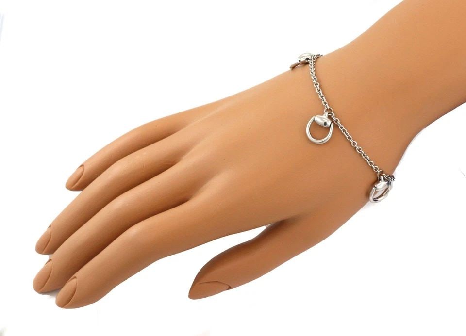 GUCCI 18K WHITE GOLD 5 HORSEBIT DANGLE CHARMS CHAIN BRACELET LIQUIDATION: GUCCI 18K WHITE GOLD 5 HORSEBIT DANGLE CHARMS CHAIN BRACELET Gucci 18k White Gold 5 Horsebit Dangle Charms Chain Bracelet Description This is an elegant authentic bracelet from Gucci, it is crafted fr