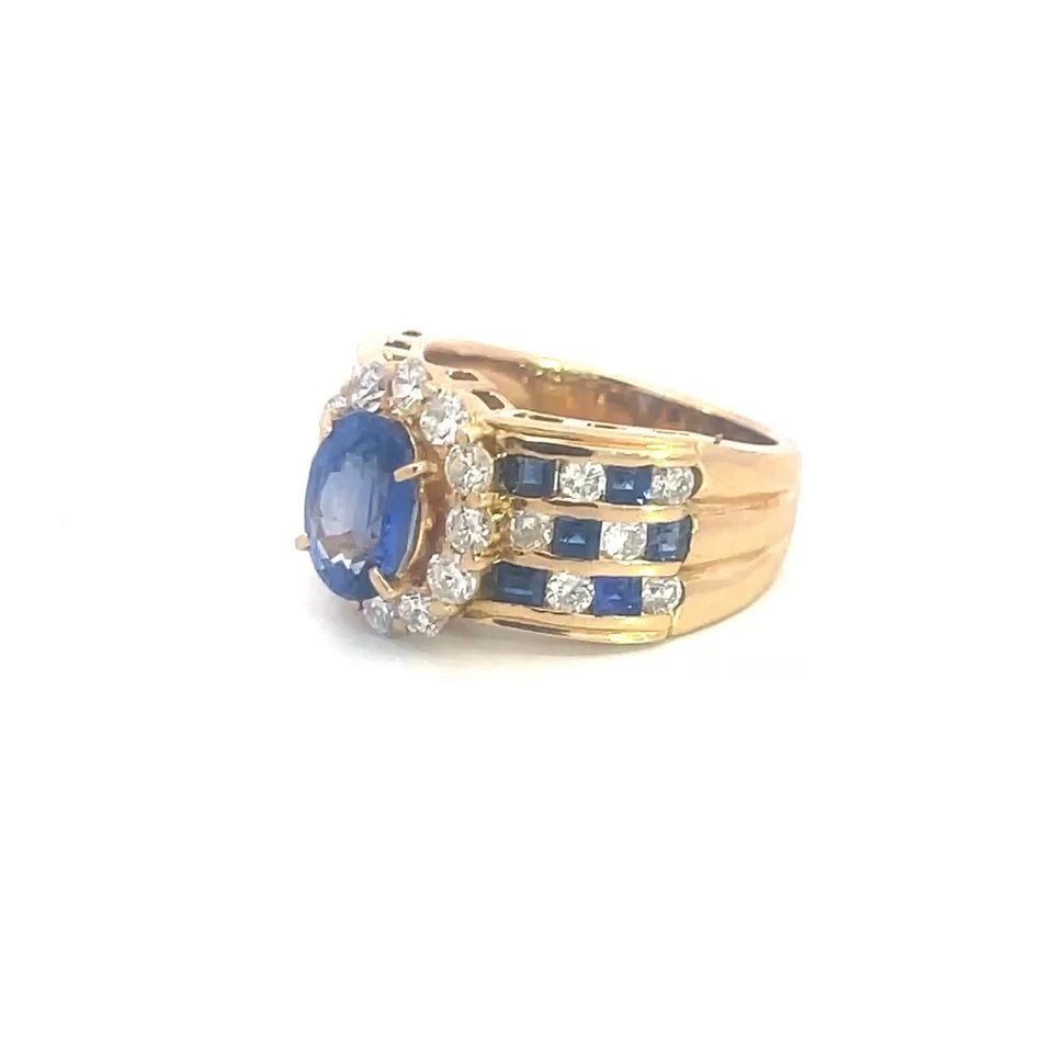 DIAMOND SAPPHIRE GOLD RING 18K YELLOW COCKTAIL OVAL TOP 5.25: This lovely cocktail ring features an oval top with a beautiful oval cut prong set sapphire surrounded with diamonds. The ring also includes square cut sapphire with round cut diamonds along the tripl