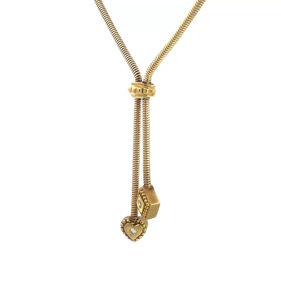 DIAMOND GOLD BOLO STYLE NECKLACE VINTAGE 14K YELLOW ROUND SNAKE CHAIN LARIAT: This diamond and gold necklace is a vintage piece made of 14k yellow gold with natural round white diamond accent, one each set in a heart and square shaped dangle pendant. The necklace features a tig