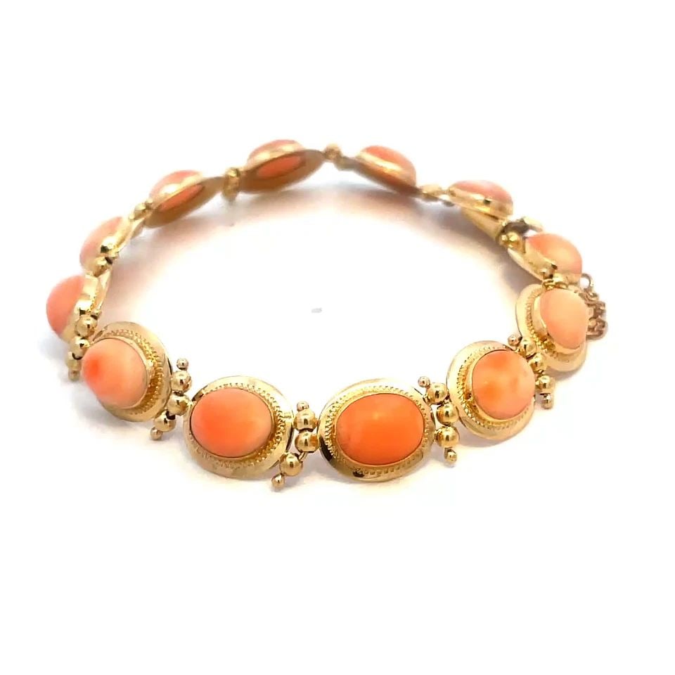 CORAL GOLD BRACELET 18K YELLOW CABOCHON OVAL SET ANGEL SKIN: CORAL GOLD BRACELET 18K YELLOW CABOCHON OVAL SET ANGEL SKIN The Coral Gold Bracelet is a vintage piece of fine jewelry crafted from 18k yellow gold. The bracelet features beautiful oval cabochon peach
