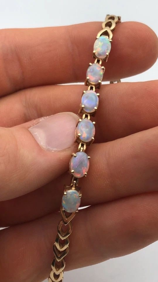 14K GOLD BRACELET WITH NATURAL AAA QUALITY OPALS ( 7.25 INCH ) 12.6G: 14K GOLD BRACELET WITH NATURAL AAA QUALITY OPALS 7.25 INCHES 14k Gold Bracelet with center row of Natural AAA Quality Opals Condition: Used Material: 14k Yellow Gold Weight: 12.6 grams Bracelet Size: 