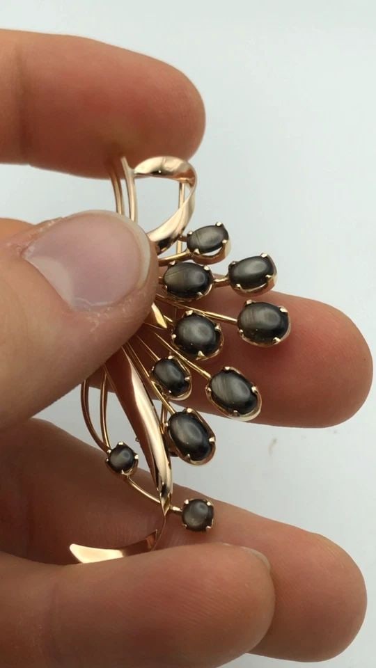 18K GOLD FLORAL BROOCH WITH BLACK STAR DIOPSIDE STONES ( 10.5 GRAMS ): 18K GOLD FLORAL BROOCH WITH BLACK STAR DIOPSIDE STONES 10.5 GRAMS 18k Gold Floral Brooch with Black Star Diopside Stones Condition: Used Material: 18k Yellow Gold Pendant Size: 63.6mm x 36mm at it's f
