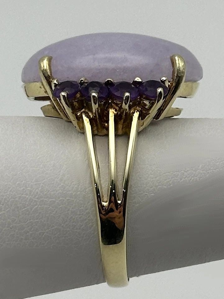 14K YELLOW GOLD RING WITH LAVENDER JADE AND AMETHYST (SIZE 7.25) 8.3 GRAMS: 14k Yellow Gold Ring with Lavender Jade and Eight Amethyst Stones Condition: Used, has marks and scratches on it Material: 14k Yellow Gold Ring Size: 7.25 Weight: 8.3 grams Top Width: 19mm Bottom Widt