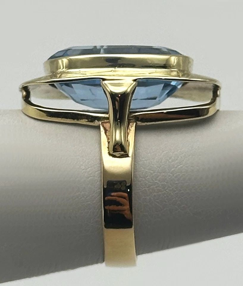 14K GOLD RING WITH 16X12MM BLUE TOPAZ (SIZE 6) 6.3 GRAM: 14k Gold Ring, Rounded off Square upper with Blue Topaz Condition: Used, There are noticeable scratches and abrasions on the Blue Topaz as seen and marked above. Material: 14k Yellow Gold Ring Size: 6