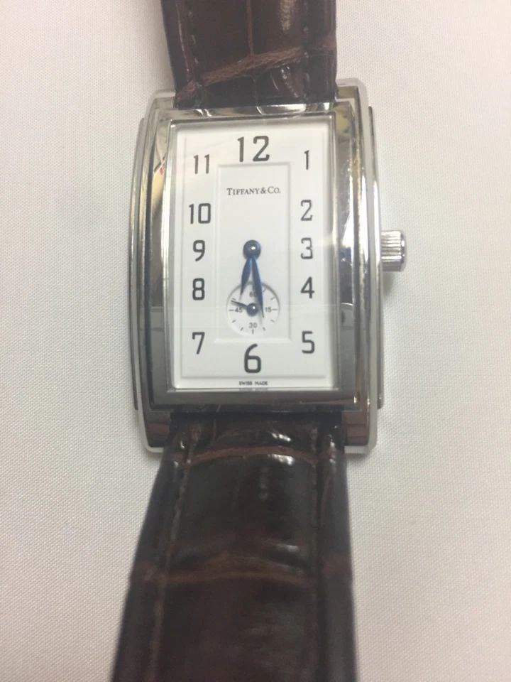 TIFFANY & CO. STAINLESS STEAL W/ LEATHER BAND UNISEX WATCH 27MM: TIFFANY & CO. STAINLESS STEAL W/ LEATHER BAND UNISEX WATCH Tiffany & Co. Stainless Steal W/ Leather Band Unisex Watch You are bidding on a pre-owned Tiffany & Co. Stainless Steal W/ Leather Band Unise