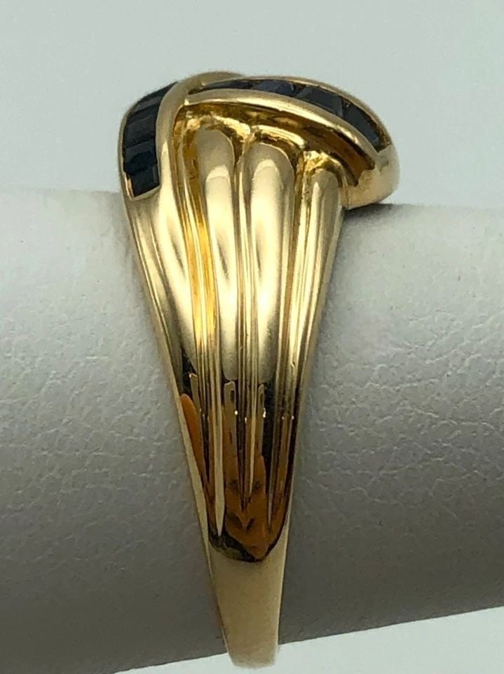 14K GOLD RIBBON STYLE RING, 0.70CTW NATURAL SAPPHIRES (SIZE 6.2) 4 GRAM: 14K GOLD MULTI LAYERED CROSSING STYLE RING WITH 0.70CTS NATURAL SAPPHIRES 14k Gold multi layered crossing style Ring with 0.70cts of Blue Sapphire Condition: Used Material: 14k Yellow Gold Ring Size: 
