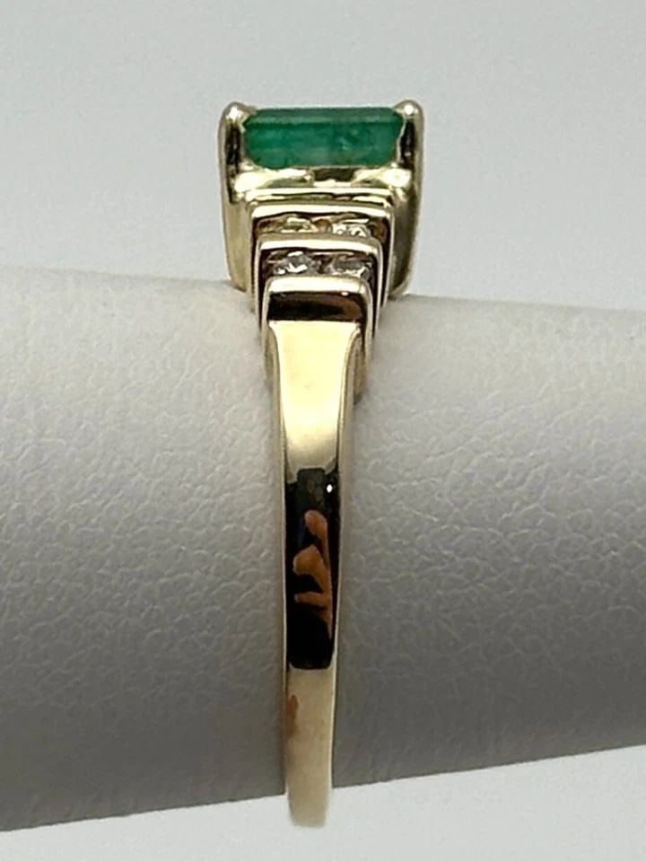 10K GOLD RING WITH NATURAL EMERALD AND 0.21CTW DIAMONDS (SIZE 5.25) 2.6G: 10K GOLD RING WITH NATURAL EMERALD AND 0.21CTS OF DIAMONDS SIZE: 5.25 10k Gold Ring with center Emerald and 0.21cts of Diamonds Condition: Used Material: 10k Yellow Gold Ring Size: 5.25 Weight: 2.6 gr
