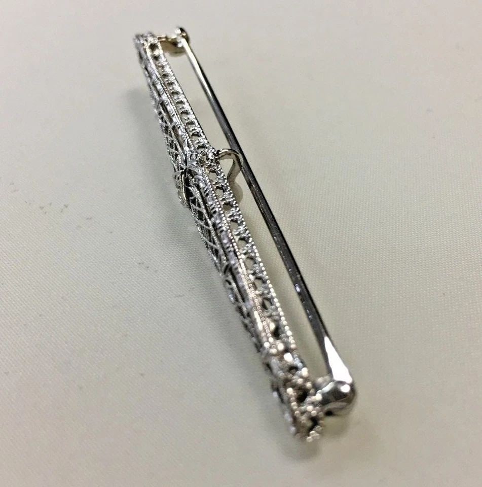 14K WHITE GOLD FILIGREE STYLE PIN/BROOCH WITH 0.15CT DIAMOND 3G: 14K WHITE GOLD PIN/BROOCH WITH DIAMOND 14k White Gold Pin/Brooch with Diamond You are bidding on a 14k White Gold Pin/Brooch with Diamond. There maybe a few minor scratches on the pin/brooch from bein
