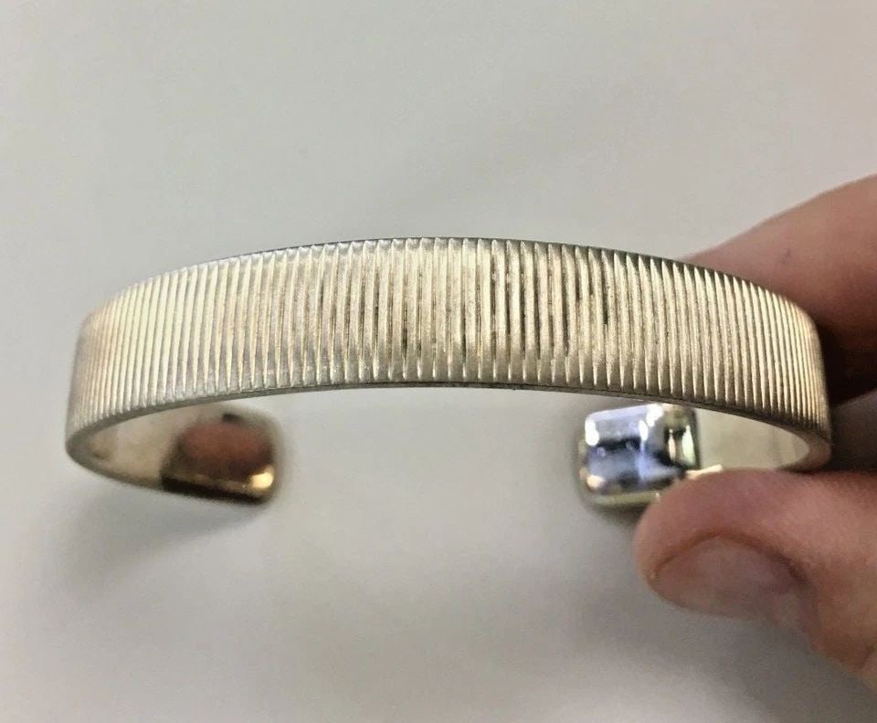 TIFFANY AND CO STERLING SILVER CUFF BRACELET, COIN EDGE, 11MM ( 41.8 GRAMS ): TIFFANY AND CO STERLING SILVER CUFF COIN EDGE Tiffany and Co Sterling Silver Cuff Coin Edge You are bidding on a pre-owned Tiffany and Co Sterling Silver Cuff Coin Edge. There are few minor scratches 