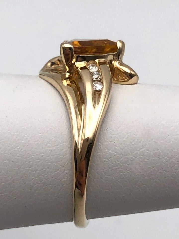 14K GOLD RING WITH TRILLION CUT CITRINE AND 0.06CTW DIAMONDS (SIZE 5.5) 2.4 GRAM: 14k Gold Ring with trillion cut Citrine and 0.06cts of Diamonds Condition: Used at some point, has been cleaned Material: 14k Yellow Gold Ring Size: 5.5 Weight: 2.4 grams Top Width: 11.8mm Bottom Widt