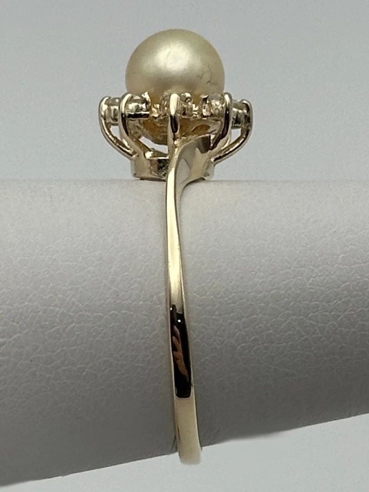 14K GOLD RING SET WITH 6.6MM PEARL AND 0.08CTW DIAMONDS (SIZE 7.5) 2.3 GRAMS: 14k Gold Ring set with 6.6mm Cultured Pearl and 0.08cts of Diamonds Condition: Used, has been cleaned Material: 14k Yellow Gold Ring Size: 7.5 Weight: 2.3 grams Top Width: 10mm Bottom Width: 1.2mm Sto