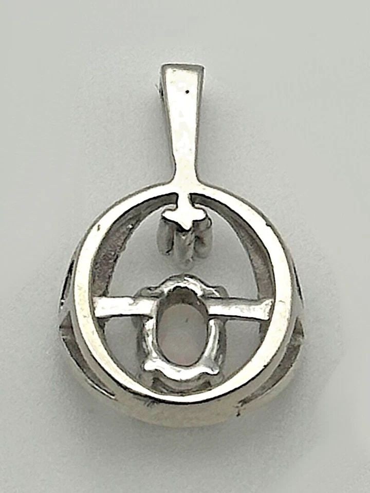 10K WHITE GOLD ROUND PENDANT WITH OPAL AND A 0.01CT DIAMOND 1.5 GRAMS: 10k White Gold Round Pendant with Opal and a 0.01ct Diamond Condition: Used Material: 10k White Gold Pendant Size: 16.5mm x 10mm , measured at it's furthest points including the bail Total Weight: 1.5