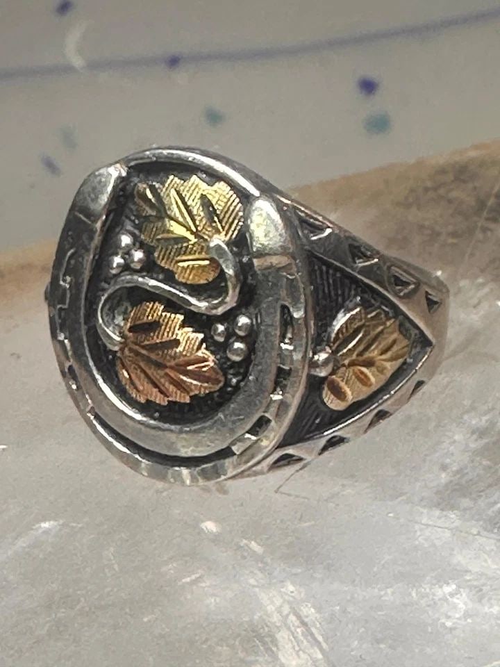 HORSESHOE RING BLACK HILLS GOLD BAND GOOD LUCK LEAVES SIZE 10 STERLING SILVER: HORSESHOE RING BLACK HILLS GOLD BAND GOOD LUCK LEAVES SIZE 10 STERLING SILVER Horseshoe ring Black Hills Gold band good luck leaves Size 10 sterling silver Size 10 Weight 9.2g Length 3/4" Width 5/8" T