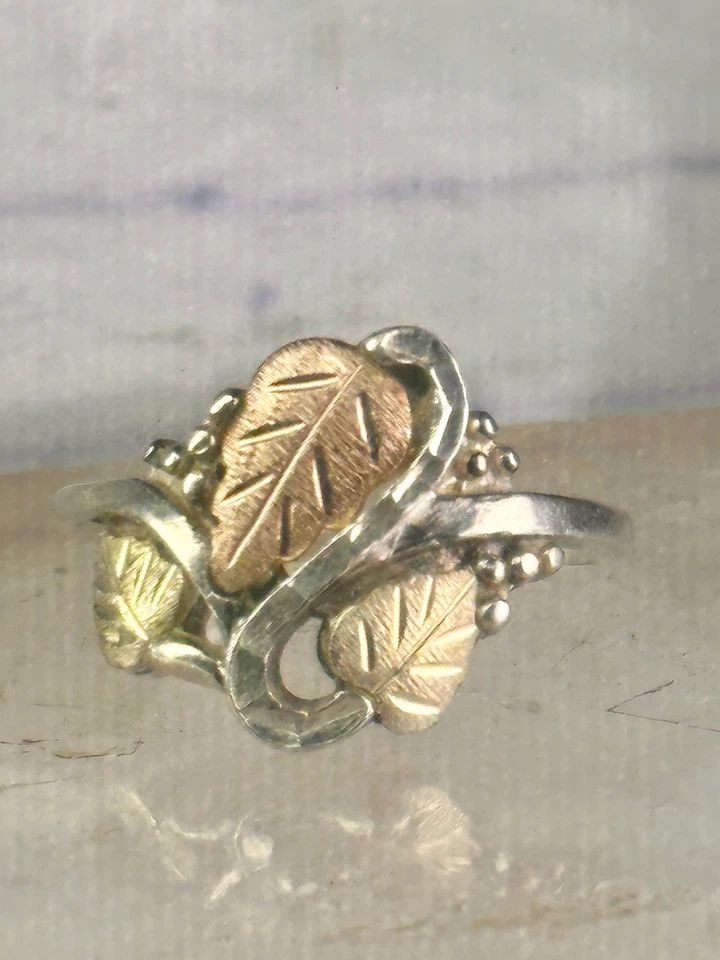 BLACK HILLS GOLD RING LEAVES BAND SIZE 10 STERLING SILVER WOMEN: BLACK HILLS GOLD RING LEAVES BAND SIZE 10 STERLING SILVER WOMEN Black Hills Gold ring leaves band size 10 sterling silver women Size. 10. Detailed with 12K over sterling silver leaves Weight 5.2g Leng