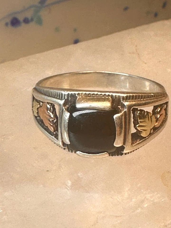 BLACK HILLS GOLD RING SIZE 9.25 ONYX LEAVES BAND WOMEN MEN: BLACK HILLS GOLD RING SIZE 9.25 ONYX LEAVES BAND WOMEN MEN Black Hills Gold ring size 9.25 onyx sterling silver leaves band women men Detailed with 12K over the sterling silver leaves Size 9.25 Weight