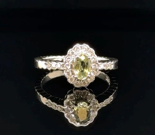 .64CT GREEN SAPPHIRE AND DIAMOND RING IN 14 WHITE GOLD: .64CT GREEN SAPPHIRE AND DIAMOND RING IN 14 WHITE GOLD Elevate your look with this stunning Unisex ring crafted in 14K white gold Featuring a captivating pear cut natural green sapphire weighing 64ct 