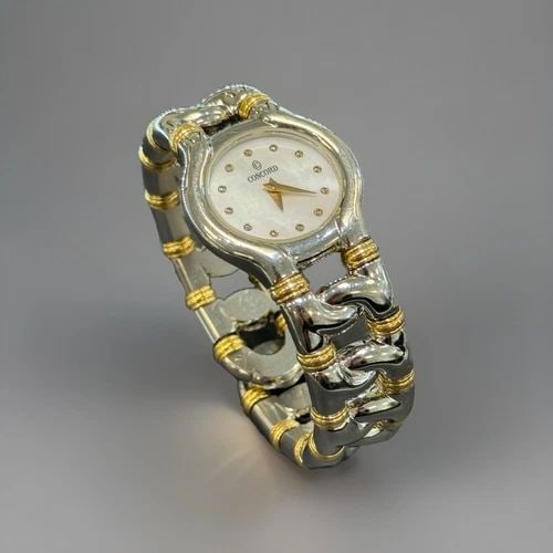 VINTAGE CONCORD LADIES WATCH WITH TWO TONE LINK CUFF BAND: VINTAGE CONCORD LADIES WATCH WITH TWO TONE LINK CUFF BAND Vintage Concord Cuff Watch Stainless Steel Band with 18kt Yellow Gold Detail White Mother of Pearl Dial 25mm Case Size Vintage Beauty! The wat