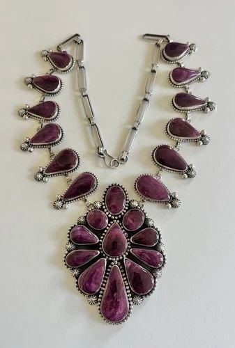 MARY ELLEN WILLIE NAVAJO HIGH GRADE NATURAL PURPLE SPINY OYSTER SHELL NECKLACE: Mary Ellen Willie Navajo High Grade Natural Purple Spiny Oyster Shell Necklace MEASUREMENTS: Necklace measures 25.25" tip to tip - Adjustable Center Pendant is 3 7/8" Tall By 2 7/8" Wide Blossom Are 1