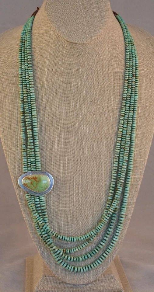 H. NEZ - 4 STRAND CRIPPLE CREEK TURQUOISE NECKLACE - SIDE SILVER PENDANT 28"-31": H. NEZ - 4 STRAND CRIPPLE CREEK TURQUOISE NECKLACE - SIDE SILVER PENDANT 28"-31" This lovely Navajo necklace has 4 strands of beautifully shaped Cripple Creek turquoise cylinder beads with fine shell 
