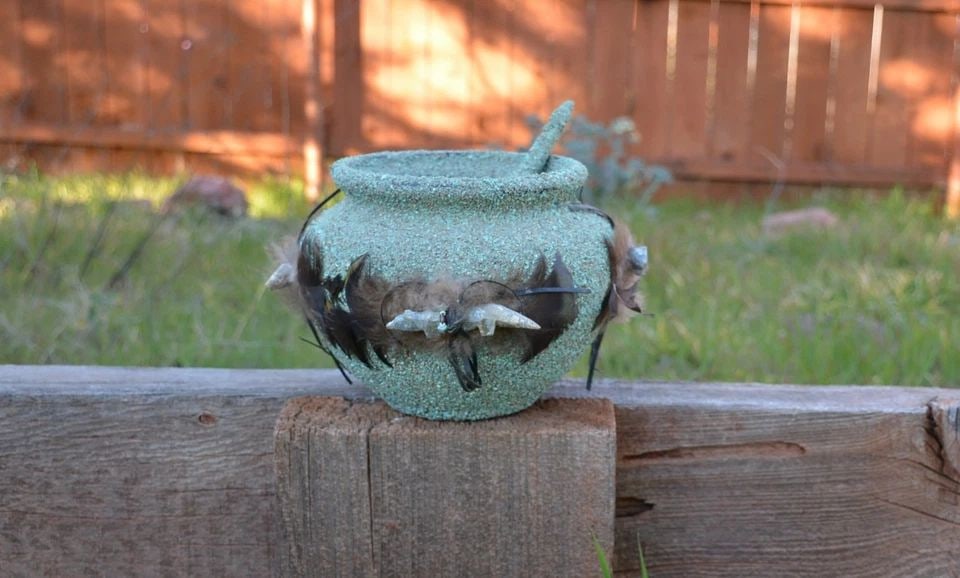 ADULT ONLY ITEM - REQUIRES VERIFICATION: ADULT ONLY ITEM - REQUIRES VERIFICATION This is a vintage Zuni ceremonial fetish pot with stick. It is encrusted with turquoise and has 4 hand carved fetishes tied to the outside of the pot. There is 