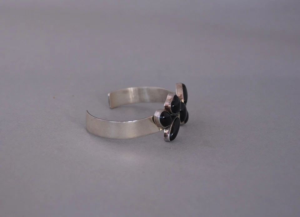 NAVAJO STERLING SILVER BRACELET - CLUSTER OF 7 BLACK ONYX STONES - 6 5/8": NAVAJO STERLING SILVER BRACELET - CLUSTER OF 7 BLACK ONYX STONES - 6 5/8" This bracelet came out of the inventory of a trading post that closed in Sedona, Arizona. It still has the original tags and i