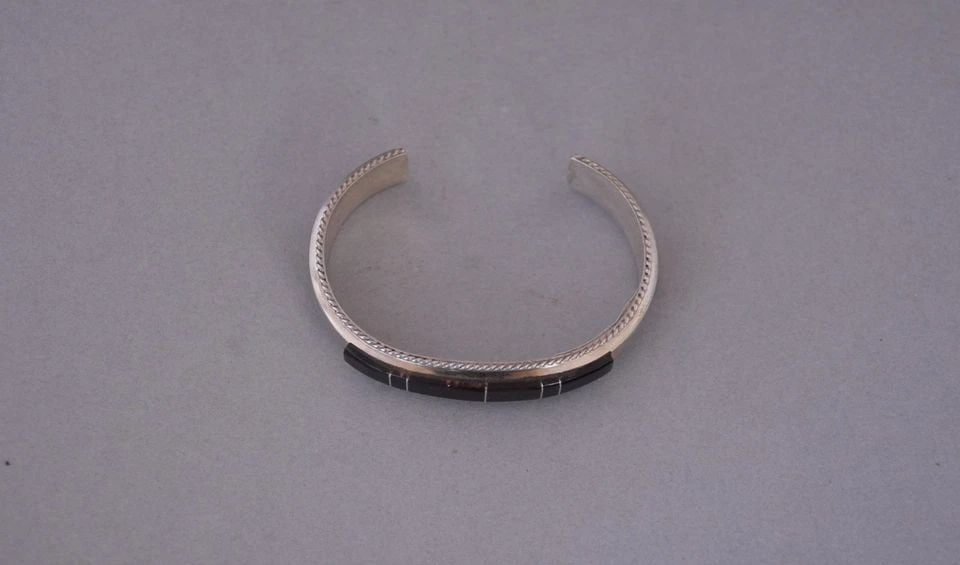 FRANCE YAZZIE - NAVAJO STERLING SILVER BRACELET - BROWN ONYX INLAY - SZ 6 1/4": FRANCE YAZZIE - NAVAJO STERLING SILVER BRACELET - BROWN ONYX INLAY - SZ 6 1/4" This bracelet came out of the inventory of a trading post that closed in Sedona, Arizona. It still has the original tags 