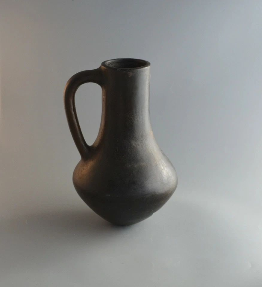 OLD NAVAJO PICHER POT ..: OLD NAVAJO PICHER POT .. Item Description: This handcrafted pot has been beautifully shaped and crafted. It is a heavy pot and measures approximately 10" tall by 7" across. There is a hole near the bo