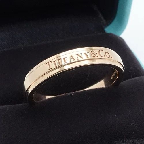 TIFFANY & CO. 18K GOLD BEVELED LOGO 4MM WEDDING BAND RING - SIZE 9 WITH RING BOX: TIFFANY & CO. 18K ROSE GOLD LOGO 4MM WEDDING BAND RING - SIZE 9 BOX Tiffany & Co. 18K Rose Gold Wedding Band Ring Size - 9 Band Width - 4mm Depth - 2mm Thick Total Weight - 6.5 Gram Hallmark - TIFFANY