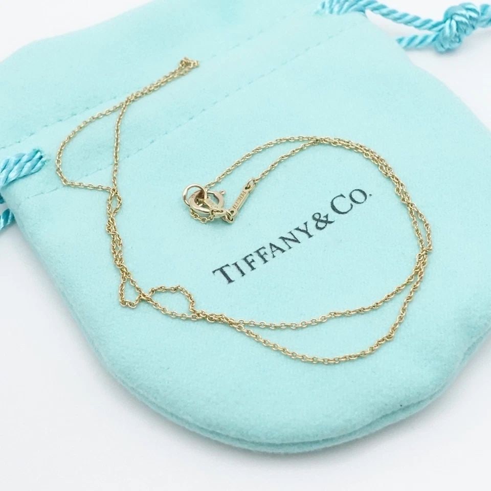 TIFFANY & CO. PERETTI 18K YELLOW GOLD 1MM CABLE CHAIN DAINTY NECKLACE 16.25": Tiffany & Co. Elsa Peretti 18K Yellow Gold Cable Chain Necklace with 14K Yellow Gold Bail Length - 16.25" Long Chain Width - 1mm approx. Total Weight - 1.6 Grams *Spring clasp is 14K & the chain itsel