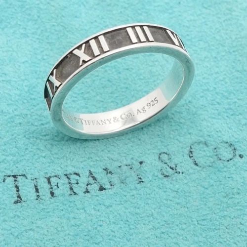 TIFFANY & CO. ATLAS STERLING SILVER ROMAN NUMERAL 4MM BAND RING - SIZE 7 POUCH: TIFFANY & CO. ATLAS STERLING SILVER ROMAN NUMERAL 4MM BAND RING - SIZE 7 POUCH Tiffany & Co. Atlas Sterling Silver Roman Numeral Narrow Band Ring with Customized engraved butterfly Size - 7 Band Width